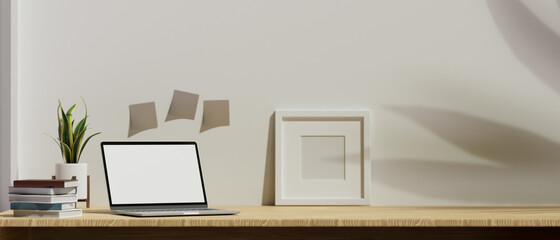 Wooden tabletop with laptop computer, decors, blank frame mockup
