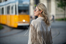 Street Style Photo Of Elegant Fashionable Woman Wearing Trendy Clothes. Model Walking In Street Of European City On Trolleybus Bus Background.