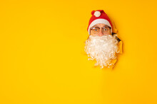 Santa Claus Looking Through Hole In Paper. Man In Santa Hat. Winter Holiday. Christmas Celebration. Merry Christmas And Happy New Year.