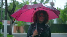 Young Black Woman Holding Pink Umbrella Outside During Rainy Day