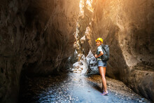 Happy Alone Woman Wearing Helmet For Safety Is Engaged In Active Canyoning And Hiking Along The Saklikent Gorge In Turkey. New Experience And Outdoor Leisure Recreation