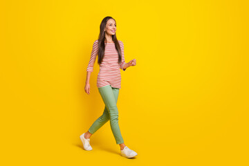 Poster - Photo of funky sweet mature lady dressed striped shirt looking empty space walking smiling isolated yellow color background