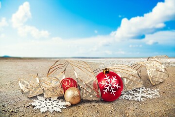 Poster - Christmas toys - colored balls on the beach, blurred sea in the background. New Year or Christmas card,