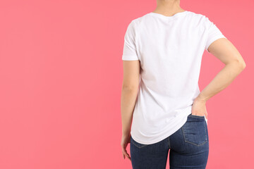 Wall Mural - Woman in blank white t-shirt on pink background