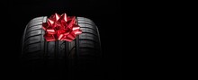 Black Isolation Rubber Tire, On The Grey Backgrounds In A Bow For Christmas