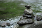 Fototapeta Desenie - Stones are piled on top of a river with surging water