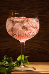 Canvas Print - Vertical shot of a glass of cocktail and mint near it on the table