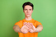 © deagreez - Photo of serious young man hold hands stop sign rejection prohibition gesture isolated on green color background