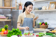 © 1112000 - image of asian woman preparing salad in the kitchen