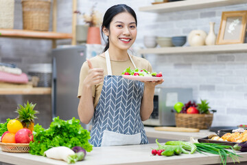 image of asian woman preparing salad in the kitchen