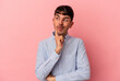 © Asier - Young mixed race man isolated on pink background contemplating, planning a strategy, thinking about the way of a business.
