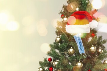 Wall Mural - Christmas tree decorated with red balls, medical white masks and a Santa hat. Coronavirus pandemic.