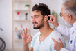 © Elnur - Young male patient with hearing problem visiting old doctor otor