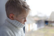 © Jacek - Sad face of a child, 7 years old boy, at home by the window.