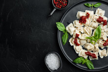 Ravioli Pasta With Mushroom Cream Sauce And Cheese - Italian Food Style With Basil Parmesan And Tomatoe On Black Plate, On Black Background , Top View Flat Lay , With Copyspace  And Space For Text