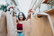 © Banana Images - African American woman is holding a pack of a paper bags to camera while smiling to camera during a happy day. Excited about new shops. New year new life style new cloths. Trendy young style