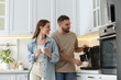 © New Africa - Happy couple preparing fresh aromatic coffee with modern machine in kitchen