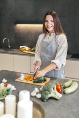 Poster - Long-haired young housewife cooking in the kitchen