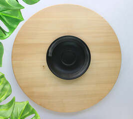 Sticker - dish is placed on a round wooden table with monstera palm leaves for decoration