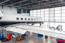 Maintenance Of Airplane In Large White Hangar