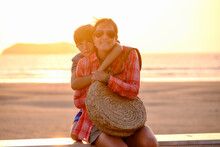 Mother And Son At Sunset With The Sea In The Background