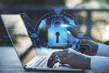 Poster - Close up of businessman hands using laptop on desktop with abstract glowing blue padlock hologram on blurry background. Internet, information, technology and security concept. Double exposure.