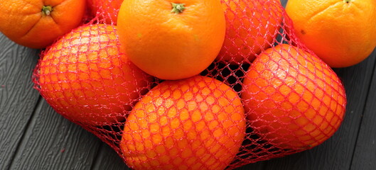 many fresh oranges in a red net 