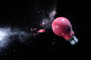 Wall Mural - explosion of a red light bulb on black.