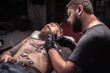 © Mr. Prof - Master of the art of tattooing doing tattoo in the salon