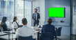 © Gorodenkoff - Office Conference Room Meeting Presentation: Businessman Talks, Uses Green Screen Chroma Key Wall TV. Successfully Presenting a Product to Group of Multi-Ethnic Investors. e-Commerce Strategy