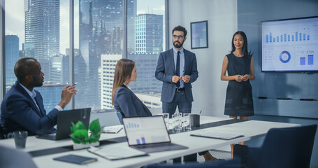 Leinwandbilder - Diverse Office Conference Room Meeting: Male Executive and Asian Female Top Manager Present e-Commerce Fintech Startup Growth Statistics to a Group of Investors. Wall TV with Infographics Data