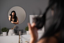 Homosexual Preening In Front Of The Mirror. A Transgender Man Combing A Wig.