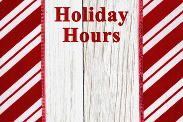 Wall Mural - Holiday Hours sign with candy cane stripes with weathered wood