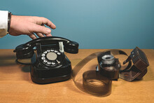 The Hand Picks Up The Receiver An Old Telephone Set On A Wooden Table, Film, Camera. Blue Background