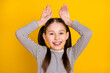 Photo of young girl happy positive smile grimace hold hands bunny ears rabbit isolated over yellow color background