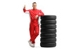 © Ljupco Smokovski - Full length portrait of a racer in a red suit leaning on a pile of tires and showing thumbs up