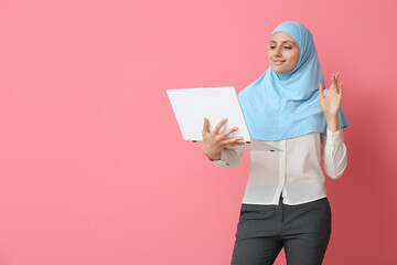 Wall Mural - Muslim secretary with laptop on color background