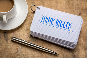Wall Mural - think bigger motivational reminder or advice - handwriting on an index card with a cup of coffee, business and lifestyle concept