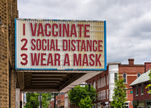 Mockup Of Movie Cinema Billboard With Vaccinate, Wear A Mask, Social Distance To Deal With The Omicron Variant Of Covid-19 Coronavirus Epidemic