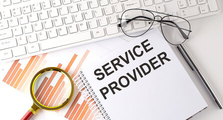 Poster - SERVICE PROVIDER text written on a notebook with keyboard, chart,and glasses