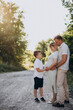 © Petro - Young pregnant woman with husband and son in a forest
