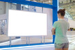 © zyabich - Woman looking at blank digital interactive white display wall at exhibition or museum with futuristic scifi interior. White screen, mock up, future, copyspace, template, technology concept