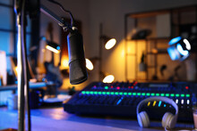 Microphone Near Table With Professional Mixing Console In Radio Studio