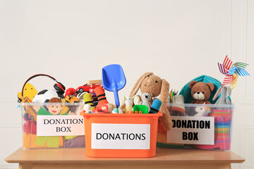 Wall Mural - Donation boxes with different child toys on wooden table