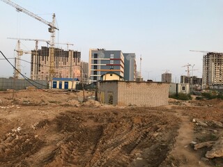 Wall Mural - dirt at a construction site. sand furrows, tracks from heavy vehicles. there are houses nearby, a booth with transformers. construction landscape