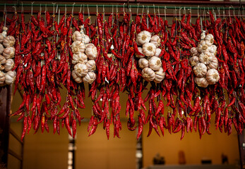 Hot red peppers and garlic hang at a farmers' market