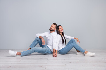 Canvas Print - Photo of dreamy guy lady dressed white shirts sitting floor holding arms closed eyes isolated concrete grey wall background