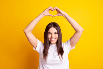 Photo of young attractive girl show fingers heart symbol feelings love romance isolated over yellow color background