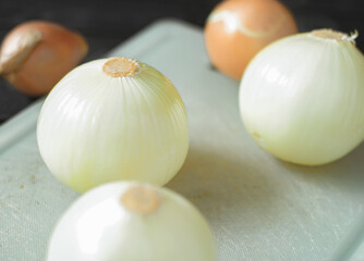 An image selected close-up focus heap onion white peeled spice taste food ingredient placed on the chopping board for eating.