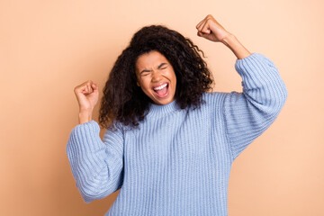 Wall Mural - Photo of young astonished lady celebrate victory success triumph fists hands isolated over beige color background